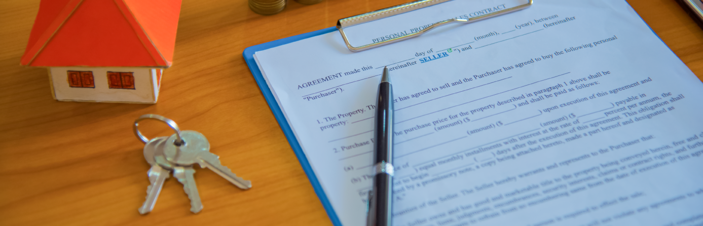 mortgage application document on a desk with keys and a small model house